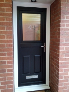 A black wood grain on white stable door with a triple glazed black house number 42 bevel.